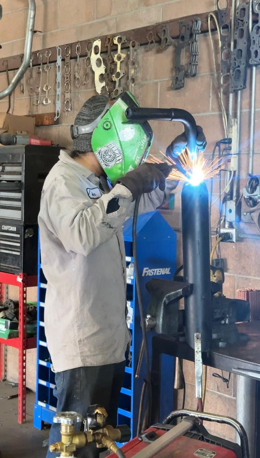 Welder fabricating custom exhaust pipe